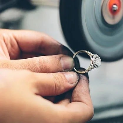 Pragnell craftsperson polishing a diamond ring by hand