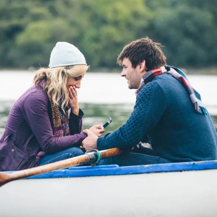 Couple on boat showing engagement ring