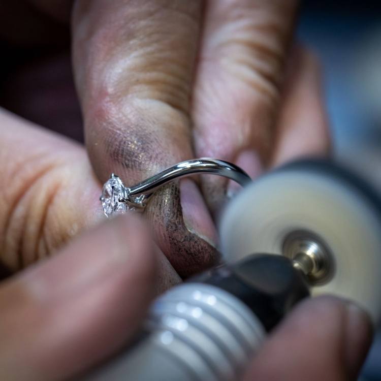 Craftsperson hand-finishing a diamond ring in the workshop