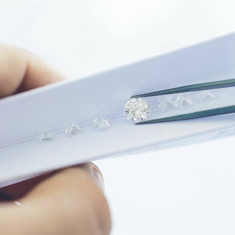 Loose Diamonds held with tweezers