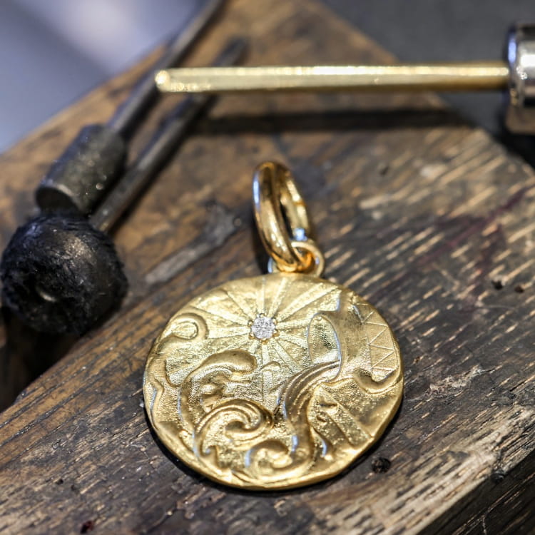 Coloured birthstones used as a discreet, hidden gemstone on a pendant for added personal meaning.