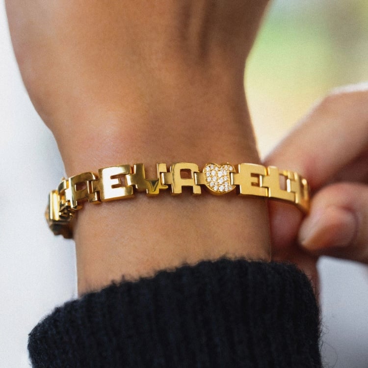 Loveletters personalised gold bracelet featuring letter-shaped links and diamond-set detailing.